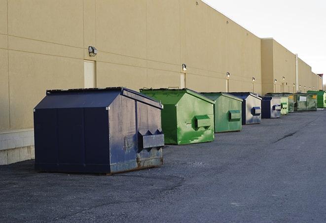 a construction worker moves construction materials near a dumpster in Kalona, IA